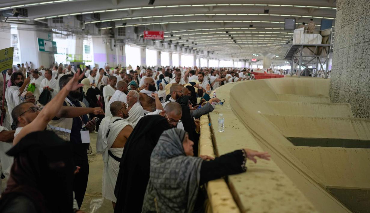 Umat Muslim berdoa sambil melakukan lempar jumrah sebagai rangkaian ibadah haji di Mina, Arab Saudi, Rabu 27 Mei 2026. (AP Photo/Altaf Qadri)