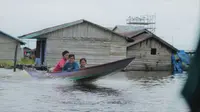 Anak-anak di pedalaman Kutai Kartanegara sedang menggunakan perahu kecil menuju lokasi bermain.