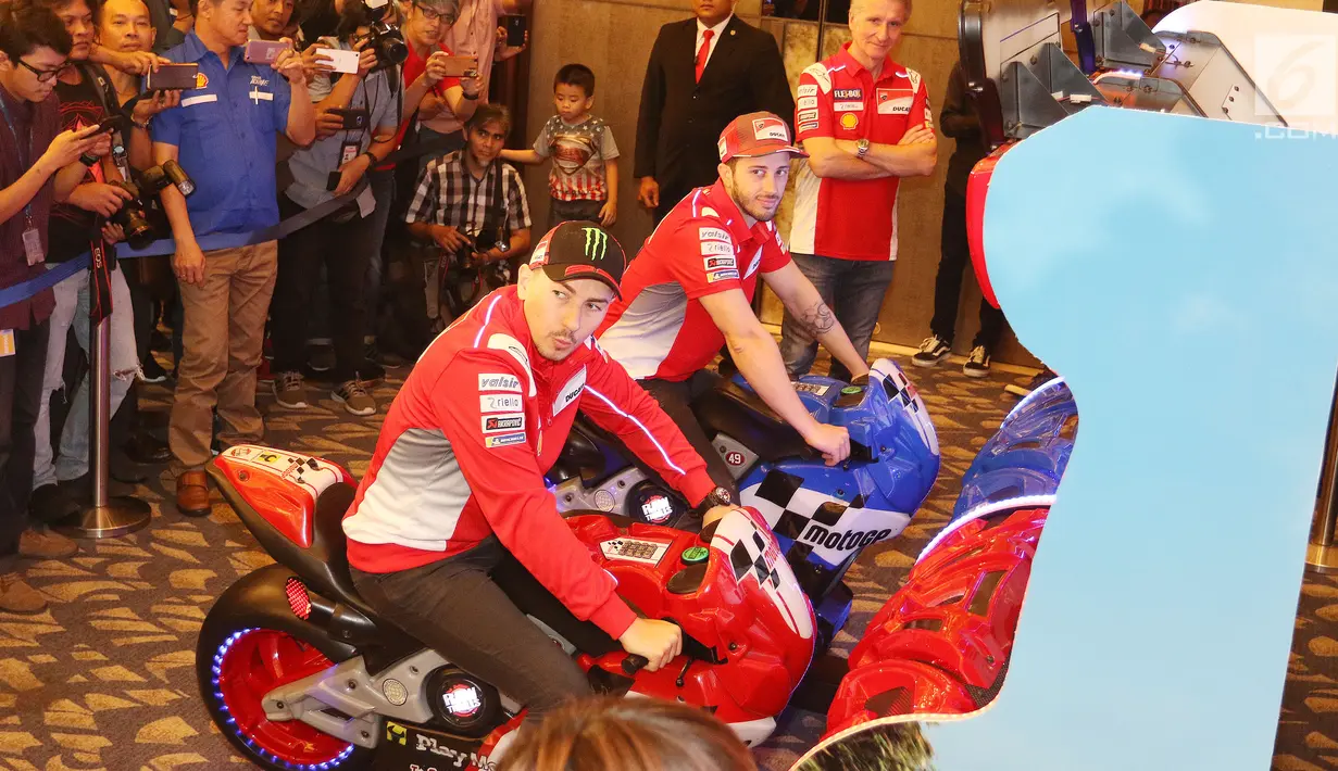 Pembalap MotoGP Andrea Dovizioso (kanan) dan Jorge Lorenzo (kiri) saat memainkan game motor balap di Jakarta, Kamis (1/2). Duo pebalap Ducati, Jorge Lorenzo dan Andrea Dovizioso, kembali berkunjung ke Indonesia. (Liputan6.com/Angga Yuniar)