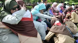 Seorang anggota pramuka (kiri) memeluk sang ibu yang tunanetra dalam kegiatan "Membasuh Kaki Ibu" secara massal  di Taman Wiladatika Cibubur, Jakarta, Rabu (21/12). Aksi massal itu dalam rangka memperingati Hari Ibu 2016. (Liputan6.com/Yoppy Renato)