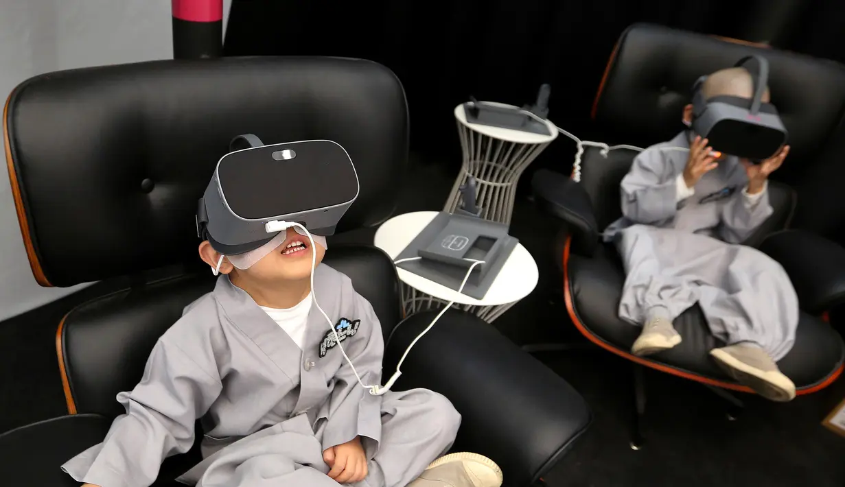 Dua anak lelaki bermain Virtual Reality (VR) menggunakan layanan 5G di tempat pengalaman LG UPlus 5G di Seoul, Korea Selatan (7/5/ 2019). Sepuluh anak terpilih mendapatkan pengalaman menjadi biksu dalam rangkaian acara peringatan hari lahir Buddha. (AP Photo/Ahn Young-joon)