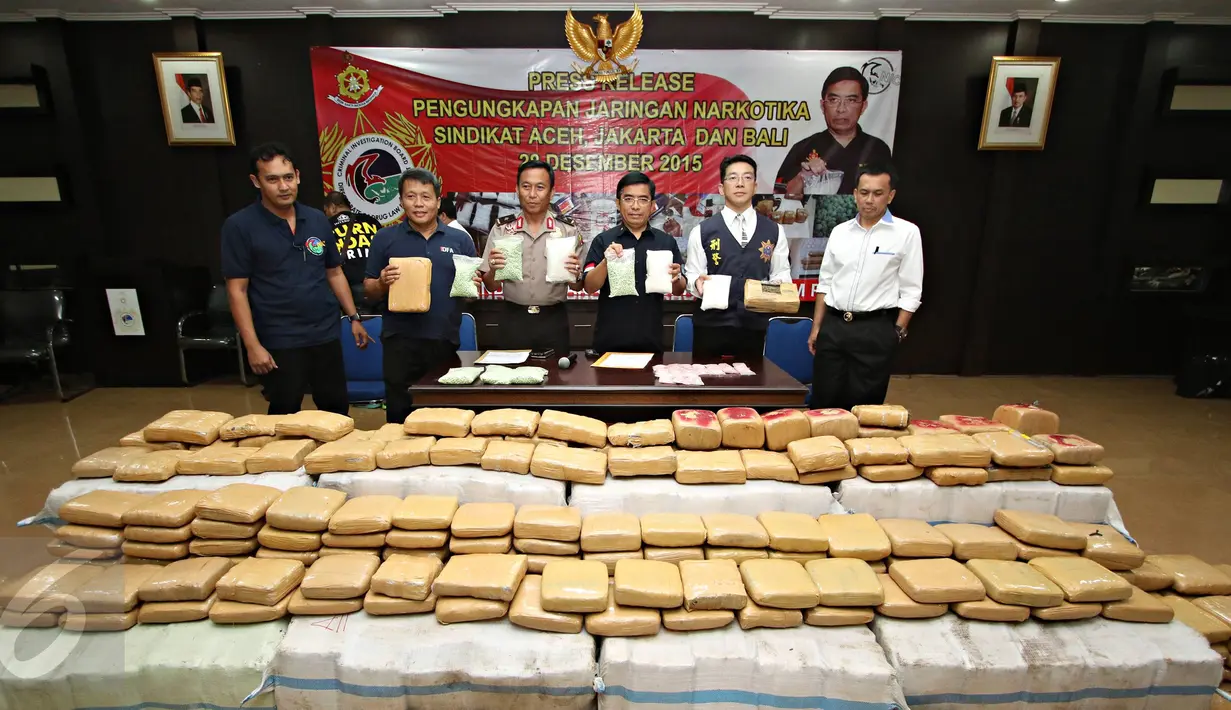 Petugas menunjukkan barang bukti dan tersangka saat rilis pengungkapan jaringan Narkotika sindikat Aceh-Jakarta-Bali di Jakarta, Senin (28/12/2015). Bareskrim amankan 3 kg sabu, 14.000 butir ekstasi, dan 1,5 ton ganja. (Liputan6.com/Immanuel Antonius) 