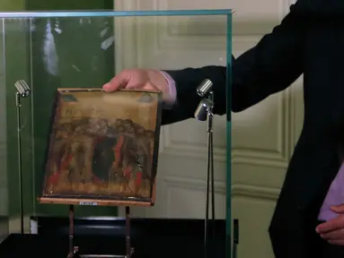 Pakar seni Stephane Pinta memperlihatkan lukisan “Christ Mocked” karya seniman Cimabue dari abad ke-13 di Paris, 24 September 2019. Lukisan yang akan dijual lewat lelang pada 27 Oktober 2019 itu diperkirakan bernilai antara 4 hingga 6 juta euro (Rp61,3 miliar-Rp92 miliar). (AP/Michel Euler)