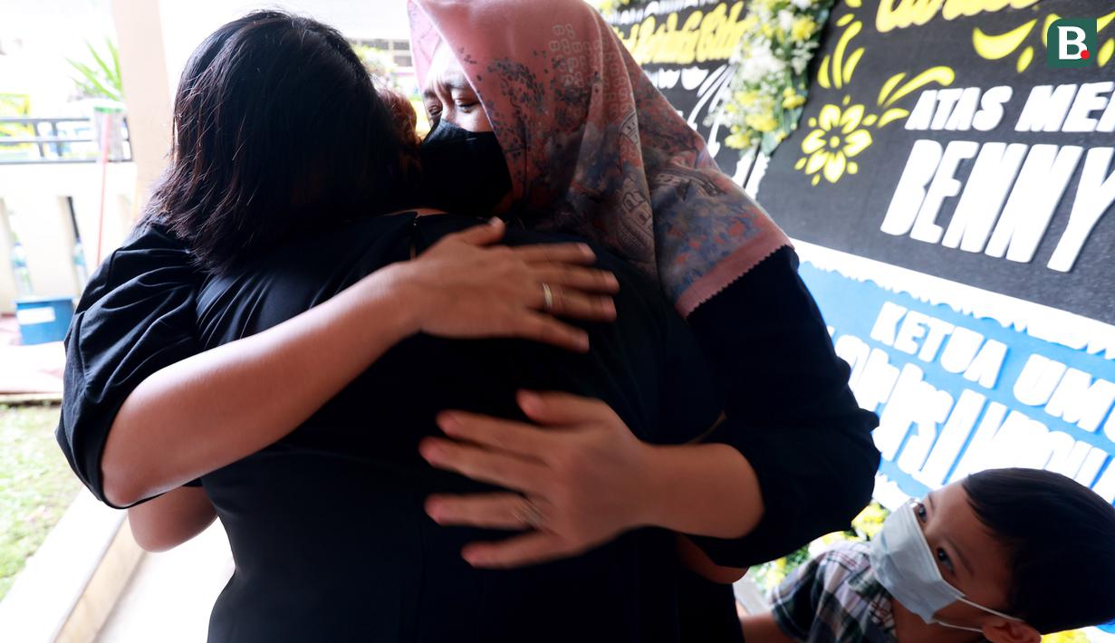 Dua orang pelayat memeluk anak almarhum eks pesepakbola sekaligus pelatih Timnas Indonesia, Benny Dolo, Jane Dolo di Pamulang Permai, Tangsel, Kamis (2/2/2023). Bendol sapaan akrabnya meninggal pada usia 72 tahun. (Bola.com/M Iqbal Ichsan)