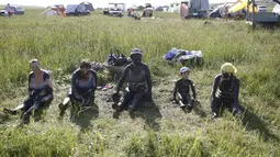 Sejumlah wisatawan duduk dengan berlumuran lumpur di tubuhnya di tepi Danau Tus, Khakassia, Siberia Krasnoyarsk, Rusia (18/7/2015). Selama musim panas, warga Rusia dari berbagai daerah melakukan perjalanan ke danau Tus. (REUTERS/Ilya Naymushin)