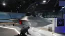 Seorang pria memeriksa jet tempur baru 'Tempest' di London, (16/7). Jet tempur ini akan dirakit dengan sistem jet BAE Systems, perakit mesin Rolls-Royce, perusahaan dirgantara Italia Leonardo dan pakar rudal asal Prancis, MBDA. (AFP Photo/Tolga Akmen)