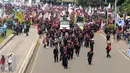 Massa buruh berjalan memasuki ruas Jalan Medan Merdeka Barat saat perayaan hari Buruh Internasional di Kawasan Patung Patung Arjuna Wiwaha, Jakarta, Senin (5/1). Ribuan massa buruh ikut dalam perayaan MayDay 2017. (Liputan6.com/Helmi Fithriansyah)