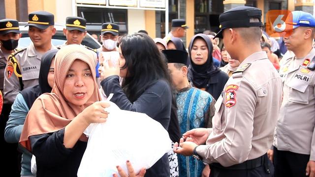 Warga saat menerima bantuan sosial dari siswa Setukpa Lemdiklat Polri angkatan ke-54 gelombang 1 di Kelurahan Cisarua, Kecamatan Cikole Kota Sukabumi. (Liputan6.com/Fira Syahrin).