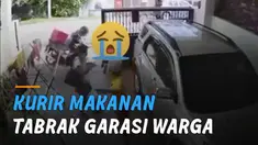 Seorang kurir bermotor pengantar makanan tiba-tiba datang dan menabrak gerbang garasi.