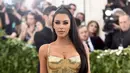 Aktris Kim Kardashian berpose saat menghadiri Met Gala 2018 di Metropolitan Museum of Art, New York (7/5). Kim Kardashian tampil seksi mengenakan gaun emas super ketat. (AP Photo/Evan Agostini)