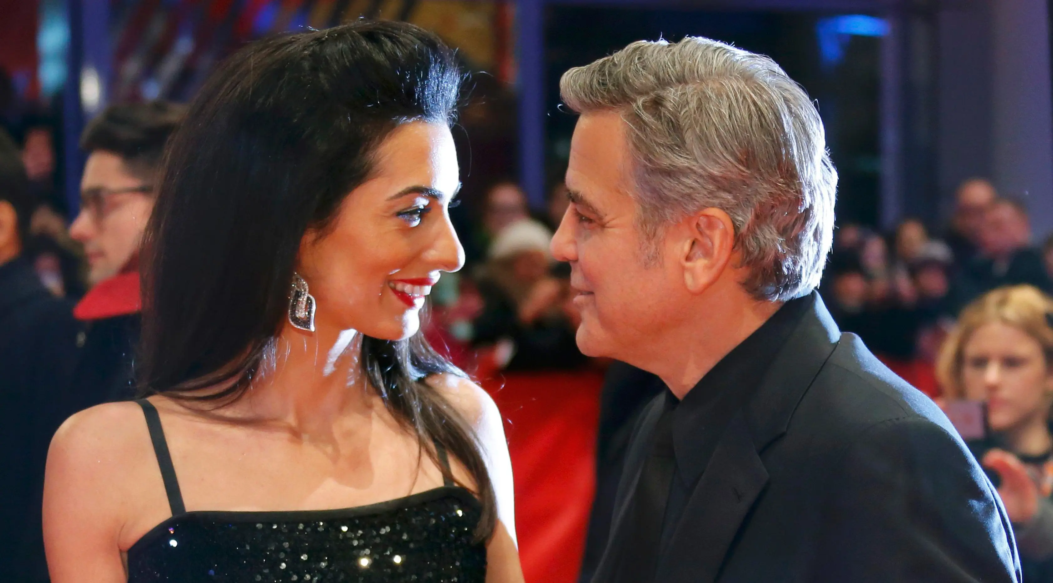 Aktor AS George Clooney dan istrinya, Amal Alamuddin berpose untuk fotografer saat tiba di karpet merah pemutaran film "Hail, Caesar!" pada pembukaan Berlin International Film Festival ke-66 di Berlin, Jerman, Kamis (11/2). (REUTERS/Fabrizio Bensch)