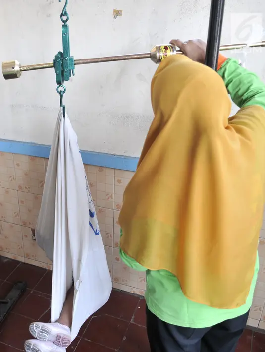 Petugas menimbang bayi saat pemeriksaan rutin kesehatan di Posyandu Ria Balita, Cipinang, Jakarta, Selasa (16/7/2019). Presiden Joko Widodo berencana memperkuat kebijakan sumber daya manusia (SDM). (merdeka.com/Iqbal Nugroho)