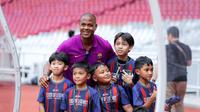 Mantan pelatih Timnas Indonesia, Patrick Kluivert, berfoto bersama sejumlah anak-anak pada coaching clinic Barcelona Legends di Stadion Utama Gelora Bung Karno, Jakarta, Jumat (17/04/2026) sore WIB. Selain memberikan coaching clinic, Kluivert juga akan tampil bersama Barcelona Legends versus World DRX Legends di SUGBK, Sabtu (18/04/2026). (Bola.com/Bagaskara Lazuardi)