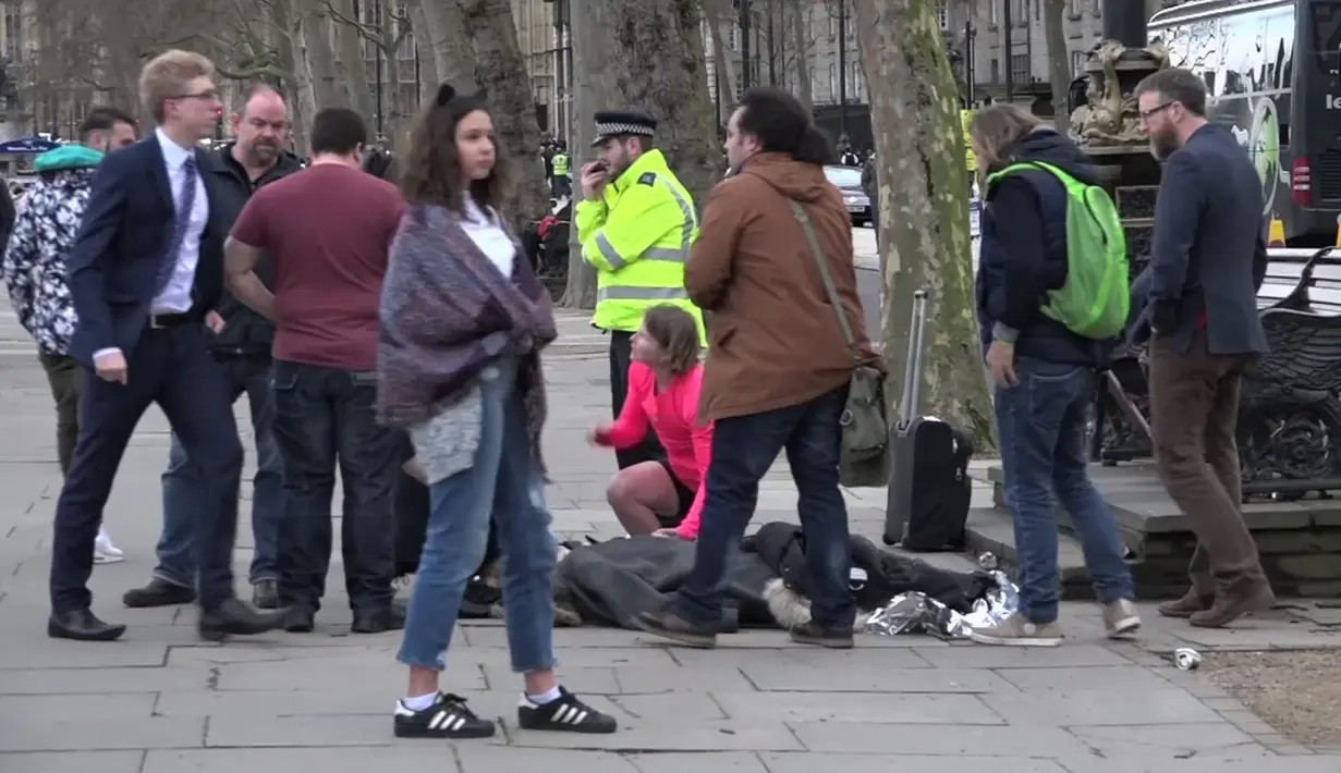Seorang wanita tergeletak setelah menjadi korban serangan teror di dekat gedung Parlemen Inggris, London, Rabu (22/3). Pelaku ditembak mati oleh anggota polisi lainnya yang berada di gedung parlemen setelah sempat menikam seorang anggota polisi (AP Photo)