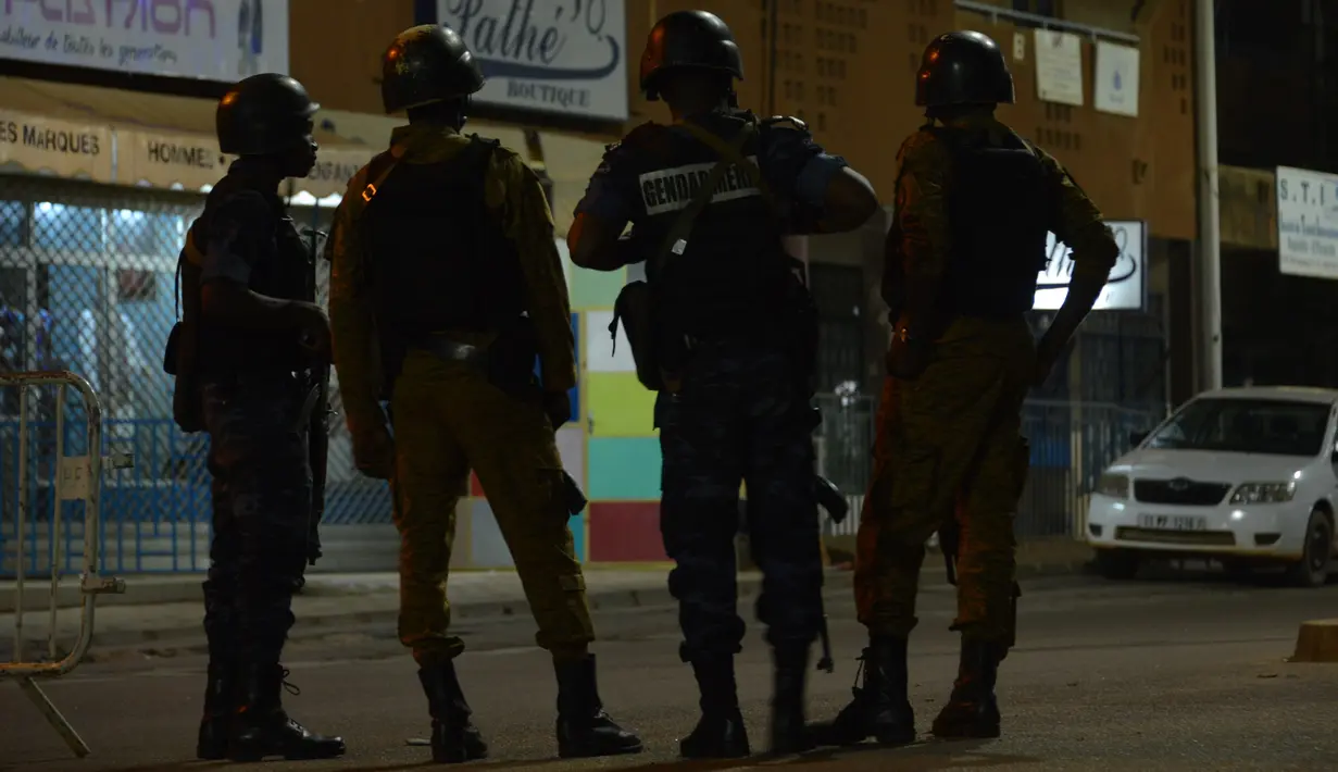 Sejumlah aparat kepolisian dan militer berpatroli di lokasi serangan oleh sekolompok orang bersenjata di sebuah kafe di Ouagadougou, Burkina Faso (13/8). Tiga orang bersenjata secara brutal menembaki pengunjung restoran. (AFP Photo/Ahmed Ouoba)