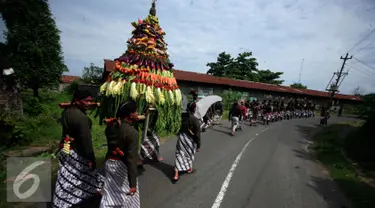 Sejumlah warga menggotong gunungan pada ritual Nyadran di dusun Kledokan, Selomartani, Sleman, Kamis (2/6). Nyadran merupakan ritual berziarah dan mengirim doa ke makam leluhur menjelang bulan Ramadan. (Liputan6.com/Boy Harjanto)