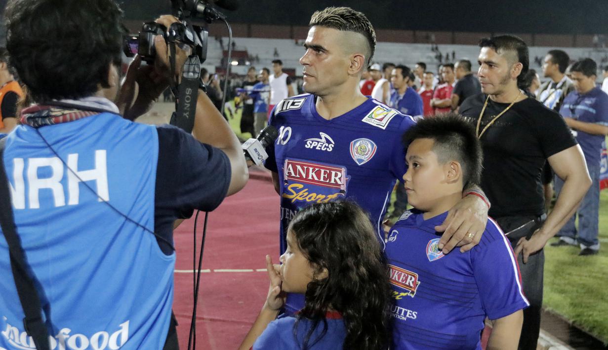 Cristian Gonzales memberikan komentar dalam sesi wawancara dengan salah satu stasiun TV ditemani oleh dua buah hatinya seusai bertanding melawan Mitra Kukar di Stadion I Wayan Dipta, Gianyar, Sabtu (17/10/2015). (Bola.com/Erwin Fitriansyah).