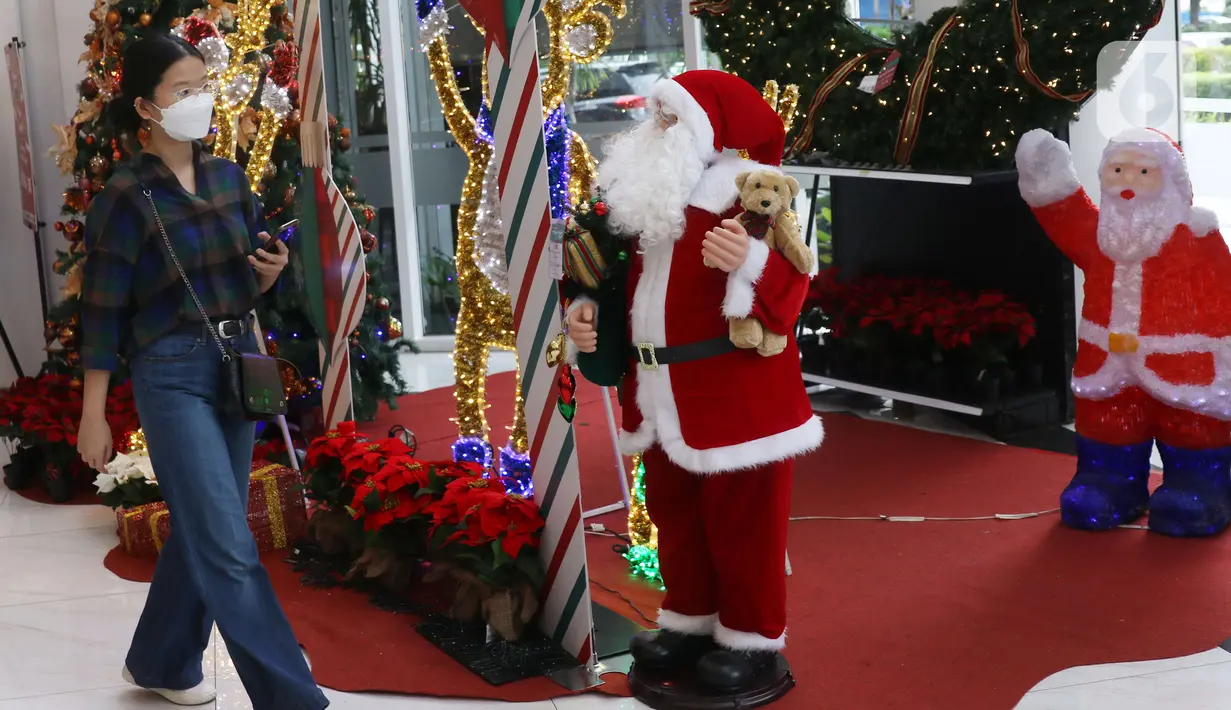 Pengunjung melintas di samping pernak pernik Natal di Living World, Tangerang Selatan, Senin (13/12/2021). Jelang perayan Natal sejumlah pusat perbelanjaan dihiasi ornamen Natal yang dijual. (Liputan6.com/Anga Yuniar)