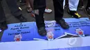 Massa menginjak poster bergambar Perdana Menteri Australia, Tony Abbott dengan mulut diplester saat menggelar aksi "Koin Untuk Australia" di Bundaran HI, Jakarta, Minggu (22/2). (Liputan6.com/Faizal Fanani)