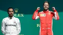 Gaya pembalap Ferrari, Sebastian Vettel (kanan) dan pembalap Mercedes Lewis Hamilton (kiri) usai memenangkan F1 GP di Sirkuit Silverstone, Inggris, Minggu (8/7). Vettel berhasil mengungguli Lewis Hamilton. (AP Photo/Luca Bruno)
