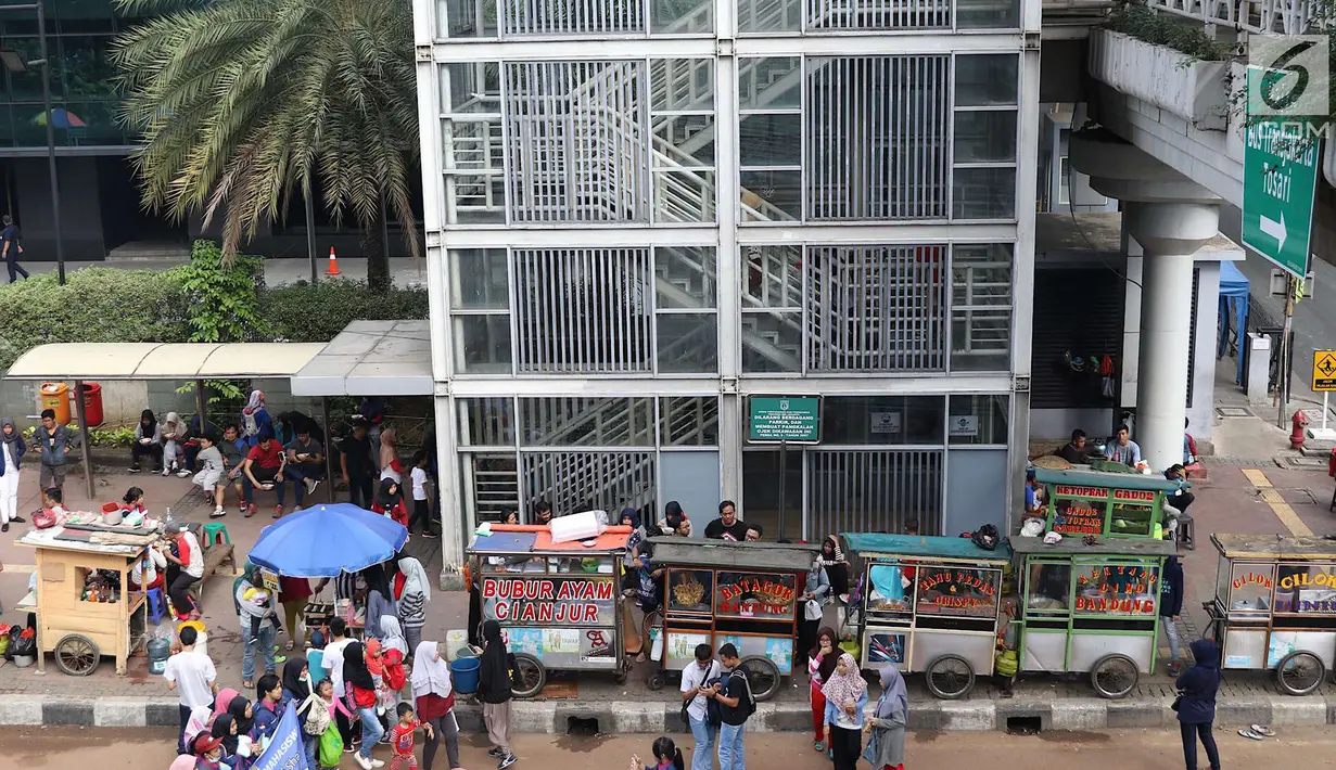 Suasana di sepanjang Jalan Sudirman saat pelaksanaan car free day Jakarta, Minggu (1/7). Kurangnya pengawasan menyebabkan banyak PKL yang berjualan tidak pada tempatnya dan memenuhi area CFD. (Liputan6.com/Immanuel Antonius)