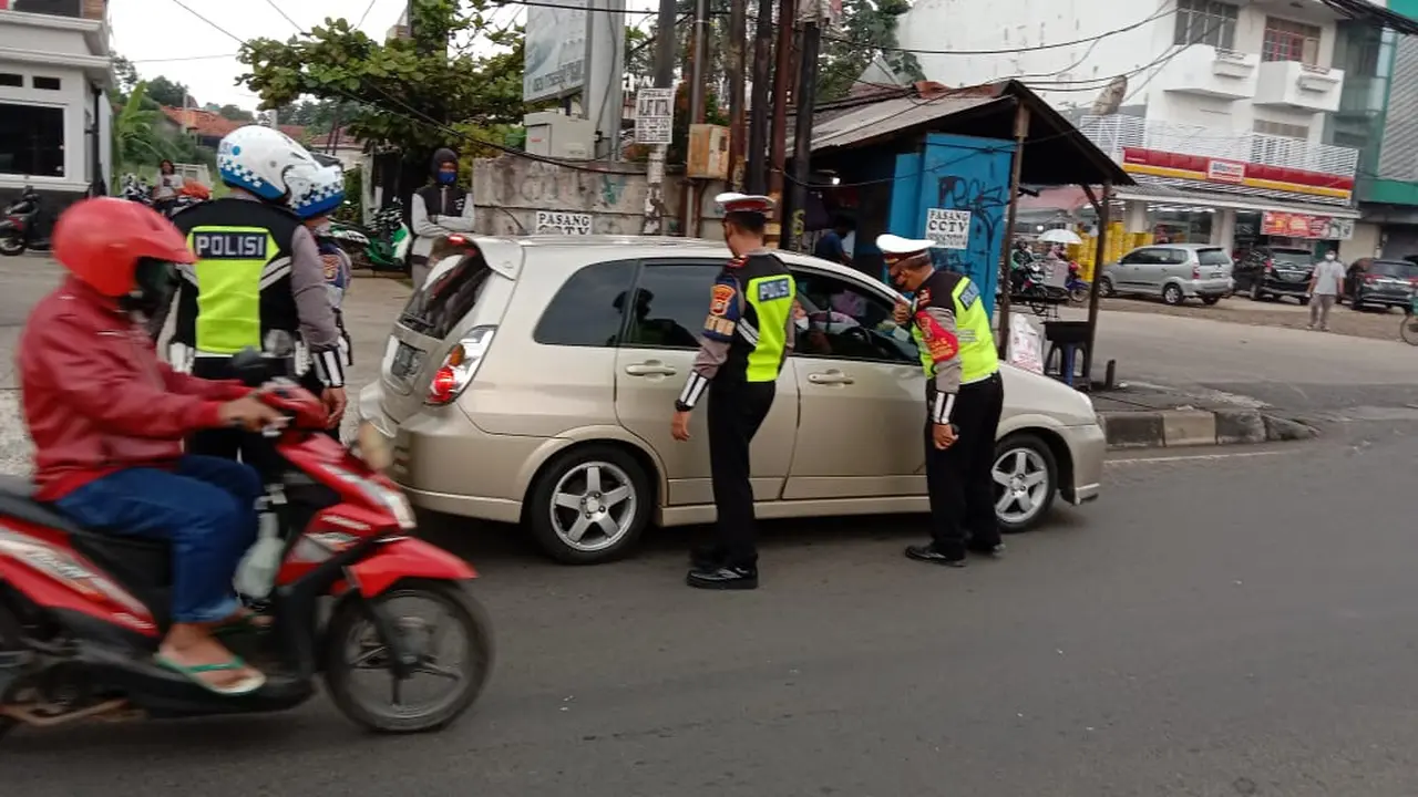 Anggota Satlantas Polres Metro Depok saat memutar balik kendaraan pemudik di Jalan Raya Ciputat-Parung, Kecamatan Bojongsari.
