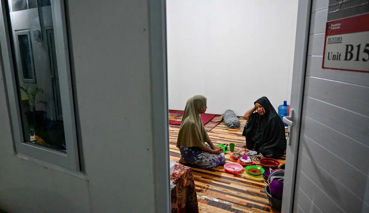 Disusul Aceh Timur dengan 1.554 unit, kemudian Aceh Tamiang sebanyak 1.295 unit, dan Gayo Lues sebanyak 1.148 unit. Kemudian Bener Meriah ada 777 unit, diikuti Pidie Jaya sebanyak 590 unit, serta Aceh Tengah dengan 475 unit. Tampak dalam foto, para penghuni yang menempati perumahan sementara yang dibangun oleh Badan Pengelola Investasi Daya Anagata Nusantara (Danantara) terlhat bersiap untuk makan sahur sebelum memulai puasa Ramadan di Meureudu, Kabupaten Pidie Jaya, provinsi Aceh, pada Minggu 22 Februari 2026, setelah banjir dan tanah longsor dahsyat melanda Sumatra, akhir tahun lalu. (CHAIDEER MAHYUDDIN/AFP)