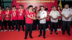 Manajer Tim Bulu Tangkis Indonesia Shendy Puspa (tengah kiri) menyerahkan trofi Badminton Asia Mixed Team Championships 2025 kepada Sekretaris Jenderal PBSI, Ricky Soebagja (tengah kanan) saat penyambutan tim bulu tangkis Indonesia di Terminal 3 Bandara Soekarno Hatta, Tangerang, Senin (17/02/2025). (Bola.com/Bagaskara Lazuardi)
