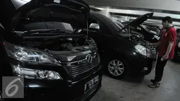Petugas membersihkan mesin mobil hasil sitaan para tersangka kasus korupsi di Rumah Penyimpanan Benda Sitaan Negara, Jakarta, Selasa (6/12). Anggaran untuk perawatan Rupbasan yang saat ini teralokasi 20 juta pertahun. (Liputan6.com/Helmi Affandi)
