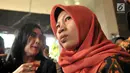Terpidana kasus pelanggaran ITE Baiq Nuril Maknun (kanan) memberi keterangan saat tiba di Kantor Kemenkumham, Jakarta, Senin (8/7/2019). Guru honorer itu divonis 6 bulan penjara dan denda Rp 500 juta atas perekaman pelecehan seksual yang dialaminya. (merdeka.com/Iqbal Nugroho)