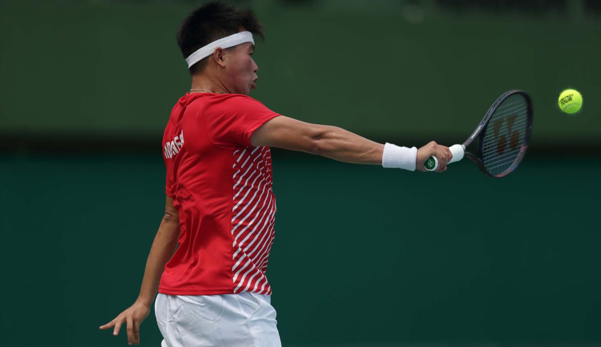 Petenis Indonesia, David A. Santoso, berusaha mengembalikan bola saat melawan petenis Selandia Baru, Rhett Purcell, pada laga Piala Davis 2019 Grup II Zona Asia/Oceania di Stadion Tenis GBK, Jakarta, Sabtu (14/9). David kalah  6-3, 4-6, 0-6 dari Rhett. (Bola.com/Peksi Cahyo)