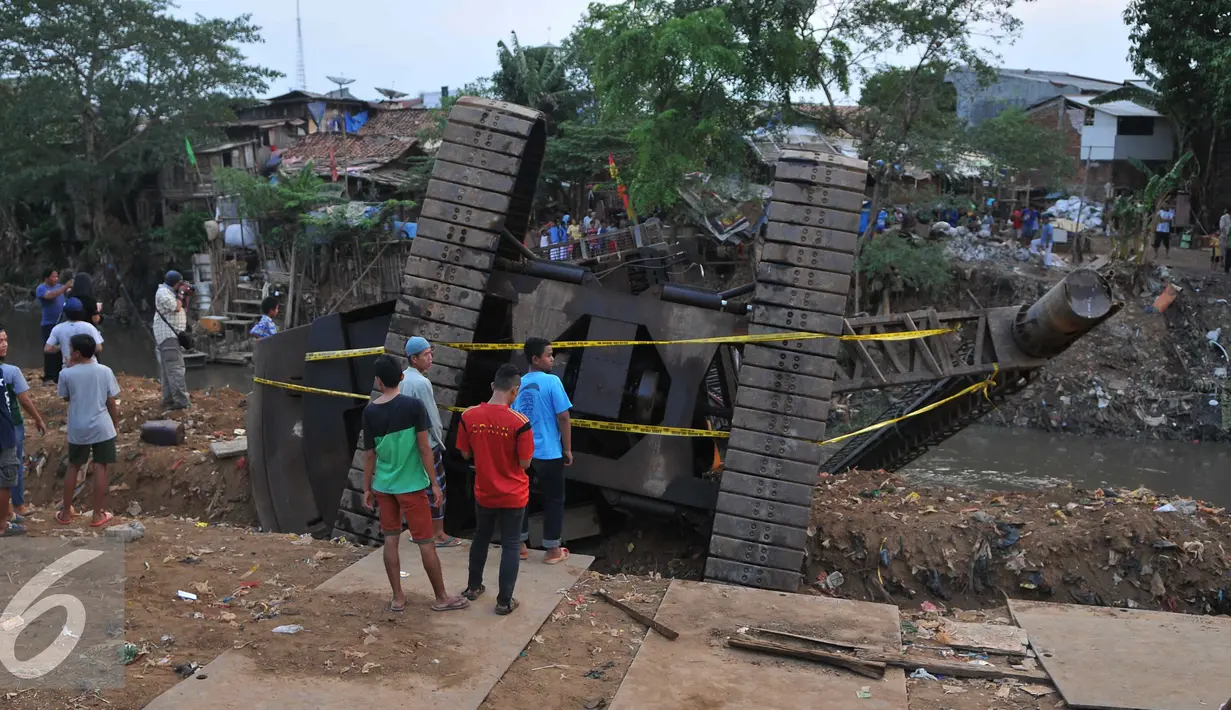 Warga melihat Crane yang jatuh ke Sungai Ciliwung Kelurahan Bukit Duri, Jakarta Selatan  (1/10/15). Akibatnya seorang warga RT15/10 Kelurahan Bukit Duri, Jakarta Selatan harus mendapatkan perawatan medis. (Liputan6.com/Gempur M Surya)