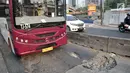 Bus Transjakarta melintas di jalan Galunggung yang rusak dan berlubang di Setia Budi, Jakarta, Selasa (30/7/2019). Jalan yang rusak tersebut mengakibatkan bus melaju dengan kecepatan lambat. (merdeka.com/Iqbal S Nugroho)