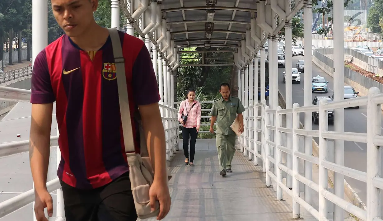 Pejalan kaki melintasi JPO Gelora Bung Karno di Jakarta, Kamis (3/5). Untuk mendukung penyelenggaraan Asian Games, Pemprov DKI Jakarta berencana merenovasi 12 JPO di kawasan Jalan Sudirman hingga MH Thamrin. (Liputan6.com/Immanuel Antonius)