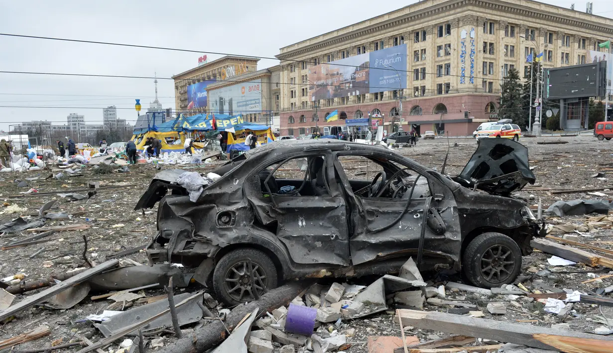 Sebuah mobil rusak di luar balai kota Kharkiv yang hancur akibat penembakan pasukan Rusia pada 1 Maret 2022. Alun-alun pusat kota terbesar kedua Ukraina, Kharkiv, dibombardir oleh pasukan Rusia -- menghantam gedung pemerintahan lokal -- kata gubernur Oleg Sinegubov. (Sergey BOBOK / AFP)