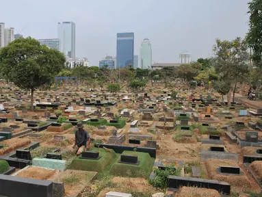 Seorang perawat makam merapikan salah satu makam di TPU Karet Bivak, Jakarta, Rabu (7/10/2015).  Pengamat Tata Kota dari Universitas Trisakti Nirwono Yoga memprediksi DKI Jakarta akan mengalami krisis lahan makam pada 2017. (Liputan6.com/Gempur M Surya)