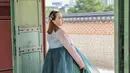 Sedangkan bagian bawah, yaitu chima atau rok hanbok, hadir dalam warna hijau botol yang mengembang indah dengan detail bordir emas di bagian hemline, menambah kesan mewah tanpa berlebihan. [@shandyaulia].