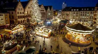 Lampu menerangi pasar Natal di Frankfurt, Jerman, 22 November 2021. Pandemi COVID-19 membuat upacara pembukaan dibatalkan, lebih sedikit stan didirikan, dan polisi memeriksa apakah pengunjung mematuhi pembatasan COVID-19. (AP Photo/Michael Probst)