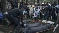 Relawan Palang Merah Kongo dan penduduk Nyamukubi membungkus jenazah orang yang tewas dalam banjir besar di bagian timur Republik Demokratik Kongo dengan selimut, pada 6 Mei 2023. (AFP)