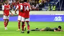 Gelandang Arsenal, Reiss Nelson (kiri) merayakan dengan rekan setimnya setelah mencetak gol ke gawang AC Milan selama pertandingan Dubai Super Cup 2022 di di stadion al-Maktoum di Uni Emirat Arab (13/12/2022). Arsenal menang tipis atas AC Milan dengan skor 2-1. (AFP/Karim Sahib)