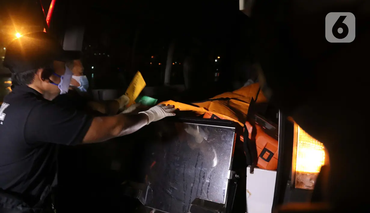 Tim DVI Polri membawa kantong jenazah yang diduga berisi bagian tubuh penumpang pesawat Sriwijaya Air SJ 182 di Dermaga JICT 2, Jakarta, Minggu (10/1/2021) dini hari. Sriwijaya Air SJ 182 hilang kontak empat menit usai lepas landas dari Bandara Soetta. (Liputan6.com/Helmi Fithriansyah)