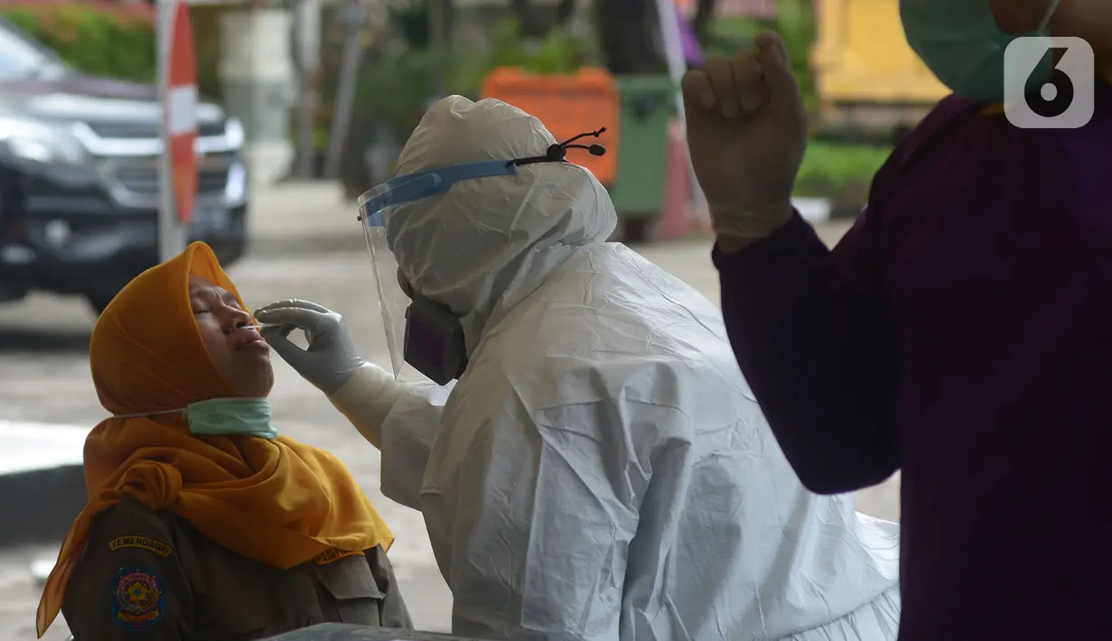 Petugas medis mengambil sampel lendir saat tes usap (swab test) pegawai kecamatan Sawah Besar, Jakarta, Selasa (18/8/2020). Tes swab yang dilakukan terhadap seluruh pegawai kecamatan Sawah Besar itu sebagai upaya memutus mata rantai penyebaran Virus Corona Covid-19. (merdeka.com/Imam Buhori)
