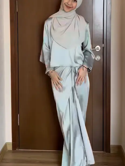 Adiba Khanza mengenakan one set bahan silk, warna hijau sage. Dari atasan lengan panjang sedikit crop dan skirt lilit. [@adiba.knza]