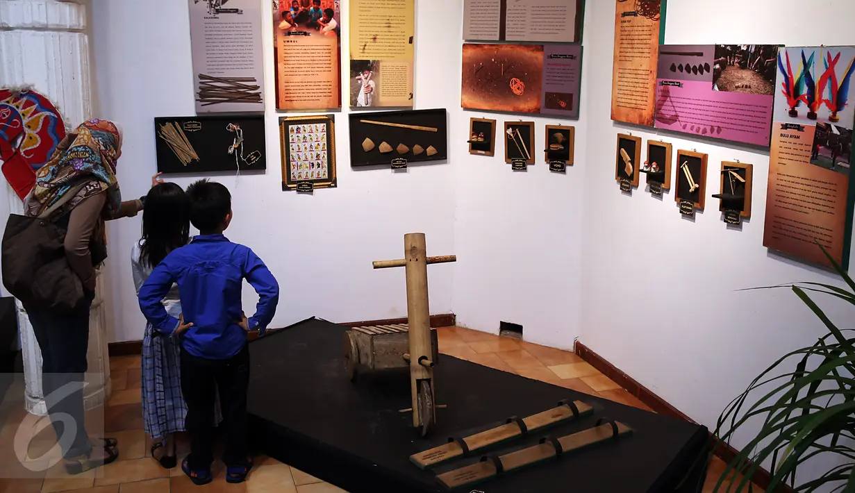 Seorang pengunjung mengajak anaknya melihat Pameran dan Gelar Dolanan Nusantara di Bentara Budaya Jakarta, Jumat (24/2). Pameran bertema tema "Menyelami Kegairahan Masa Kecil" ini berlangsung pada 22-28 Februari 2017. (Liputan6.com/Johan Tallo)