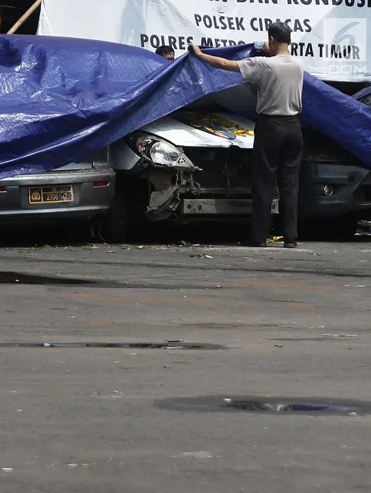 Petugas melihat melihat kondisi mobil yang dirusak di Polsek Ciracas, Jakarta, Rabu (12/12). Pelayanan di Polsek Ciracas lumpuh pascapembakaran oleh massa. (Liputan6.com/Herman Zakharia)