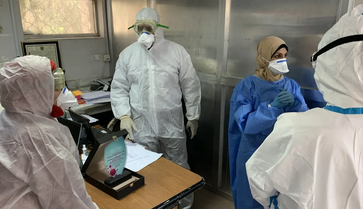 Anggota tim pakar medis China, Yang Honghui (kanan) memasuki Laboratorium Kesehatan Masyarakat Pusat di Baghdad, Irak, Kamis (26/3/2020). Sejak 7 Maret lalu, tujuh pakar medis China bekerja sama dengan tenaga ahli lokal di Irak untuk memerangi epidemi virus corona COVID-19. (Xinhua)