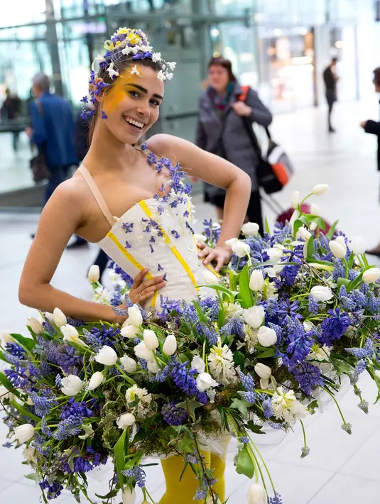 Model berpose dengan gaun yang dihiasi dengan bunga saat pameran bunga Keukenhof di Central Station di Utrecht, Belanda, (29/3). Pameran ini menghadirkan sekitar 20.000 bunga musim semi. (AP Photo / Peter Dejong)