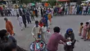 Orang-orang menerima kotak makanan dan minuman manis tradisional untuk berbuka puasa di Rawalpindi, Pakistan, Minggu, (3/5/2020). Umat Muslim di seluruh dunia sedang melaksanakan Ramadan untuk menahan diri dari makan, minum sejak subuh sampai senja. (AP/Anjum Naveed)