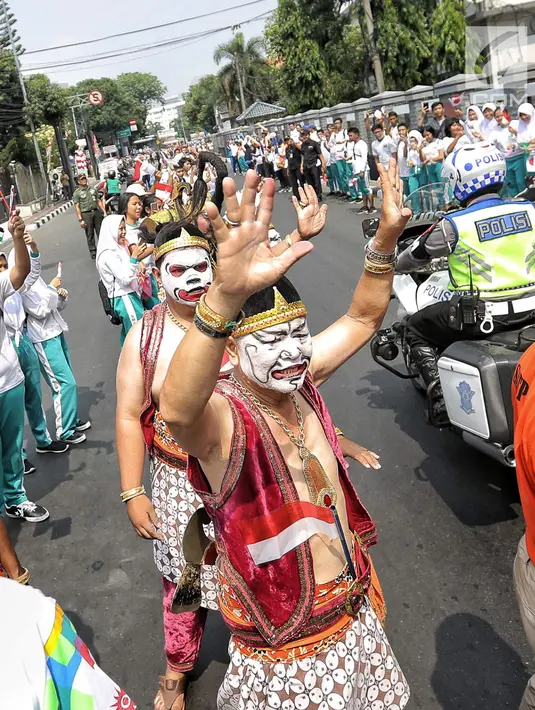 Wayang orang sambut obor Asian Games 2018 yang melintas di RSPAD Gatot Subroto - Hotel Borobudur Jakarta, Kamis (16/8). Pawai obor yang memasuki hari kedua dimulai dari Balai Kota DKI Jakarta dan berakhir di Gor Sunter.(Liputan6.com/Faizal Fanani)