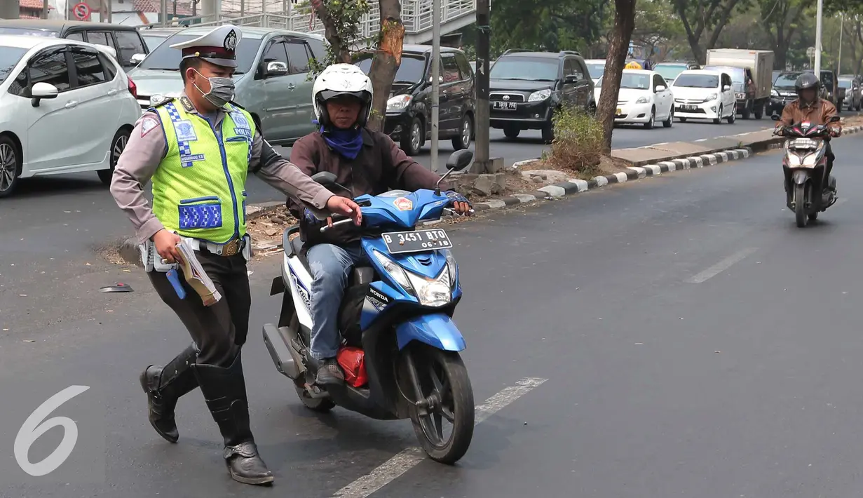Petugas polisi saat memberhentikan pengendara motor di kawasan Cempaka Putih, Jakarta, Senin (26/10/2015). Operasi Zebra 2015 berlangsung hingga 4 November 2015 bertujuan untuk menekan pelanggaran lalulintas. (Liputan6.Com/Angga Yuniar)